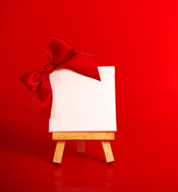 boş tuval üzerinde Noel kırmızı arka plan ile ahşap şövale 