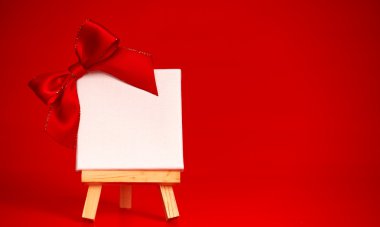 boş tuval üzerinde Noel kırmızı arka plan ile ahşap şövale 
