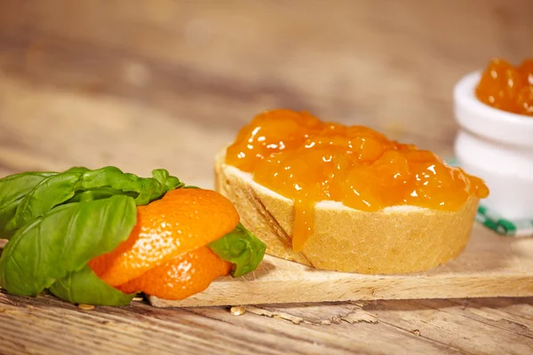 橘子果酱用片木制的桌子上的面包 — 图库照片