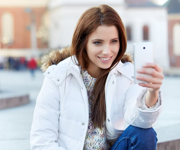 Pretty young woman taking a picture on town. Smiling girl. Winte — Stock Photo, Image