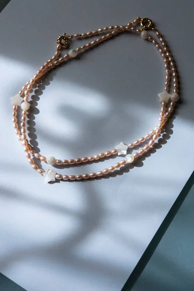 Peach pearl necklace with round and star-shaped mother of pearl