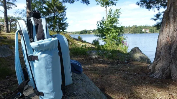 Niebieski plecak zostawiony na skałach nad jeziorem — Zdjęcie stockowe