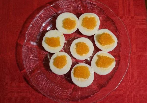 Варёные яйца с рыбьей косулей подаются на стеклянной тарелке — стоковое фото