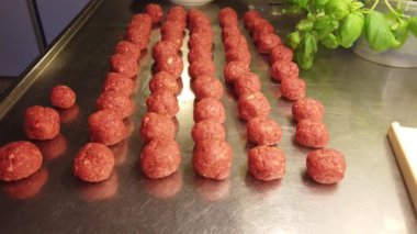 Domates sosunda pişirilmeye hazır el yapımı köfteleri gösteren 4k 'lik kısa bir video.