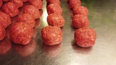 Domates sosunda pişirilmeye hazır el yapımı köfteleri gösteren 4k 'lik kısa bir video.