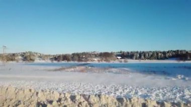 Güneş ve karla dolu bir kış gününde arabadan İskandinav manzarası