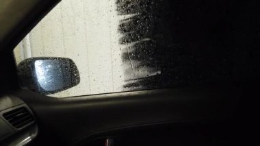 Araba yıkama fırçası arabanın yan camını yıkar.