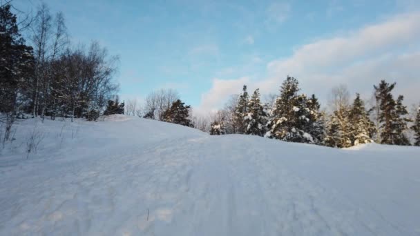 北欧の雪の丘の上の曇り空に太陽が昇る — ストック動画
