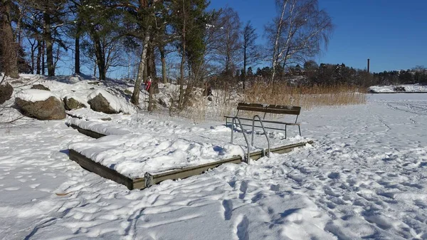 Lavička a žebřík ke koupání v stále zamrzlém jezeře v severní Evropě — Stock fotografie