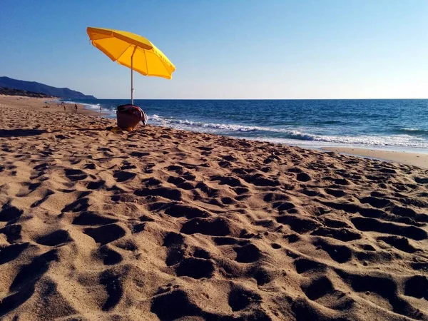 黄色のオープンビーチの傘はイタリアのサルデーニャ島の孤独なビーチに置かれています — ストック写真