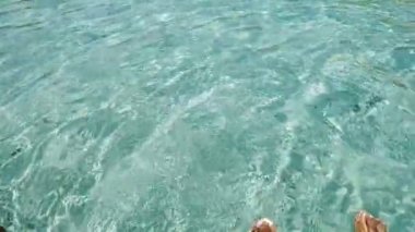 Kristal berrak deniz suyunda eğlenen iki kadının videosu.
