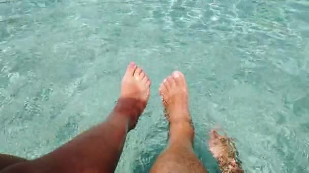 Wideo z dwoma kobiecymi stopami i dwoma męskimi stopami bawiącymi się w krystalicznie czystej wodzie morskiej — Wideo stockowe