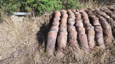 Eski terracotta çatı kiremitlerinin videosu kırsal kesimde düzgünce dizilmiş.