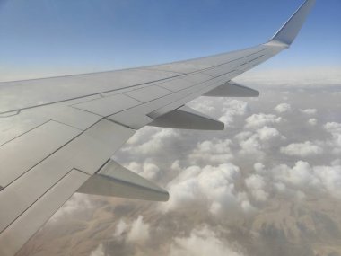 Sahil ve Deniz Üzerinde Uçan Uçak Kanadı, Kızıl Deniz, Mısır - Bir uçak penceresinden alınan yüksek irtifa hava görüntüsü Mısır 'daki çarpıcı Kızıldeniz kıyı şeridini kaplayan uçak kanadını gösteriyor.