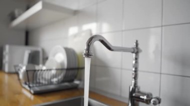 Mutfaktan akan su, lavaboya paslanmaz çelik musluktan akar. Krom musluğu açık bırakarak su israfı. Ev işleri ve faaliyetlerinde suyu kötüye kullanma. Ev suyunu fazla kullanıyorsun..