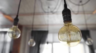 Modern mutfakta asılı büyük, eski, parlak ampuller. Düz telli dekoratif antika Edison ampulleri. Yetersiz filamantasyon ampulleri elektriği boşa harcıyor. Sıcak beyaz, loş, E27