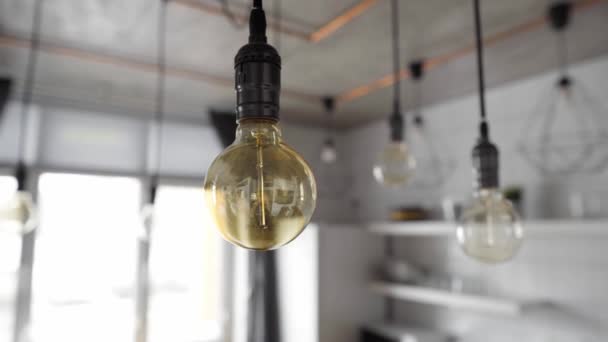 Декоративные антикварные лампочки Эдисон с прямыми проводами. Большие старинные лампы накаливания висят на современной кухне. Неэффективные лампочки накаливания тратят электричество. Размеры, теплый белый, E27 — стоковое видео