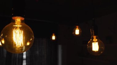 Mutfakta asılı büyük, eski, parlak ampuller. Düz telli dekoratif antika Edison ampulleri. Yetersiz filamantasyon ampulleri elektriği boşa harcıyor. Ilık beyaz loş, yol gösterici.