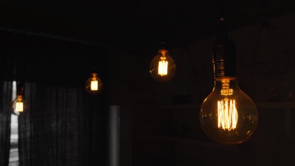 Velké starobylé žárovky visící v tmavé kuchyni. Dekorativní starožitné žárovky s rovným drátem. Neefektivní žárovky ztrácejí elektřinu. Teplo bílé stmívatelné, vedené — Stock video