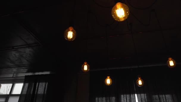 Dekorative antike Edison Glühbirnen mit geradem Draht. Große alte Glühbirnen hängen im dunklen Raum. Ineffiziente Glühbirnen verschwenden Strom. Dimmbar, warmweiß, led — Stockvideo