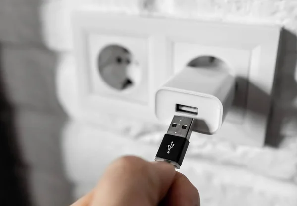 Güç adaptöründen USB kablosu çekiliyor. USB kablosunu cep telefonu şarjından çıkar. Adamın biri USB 'yi şarj aletine karşı tutsun. Avrupa 'nın duvar prizine ya da AC adaptörlü soketine eklenti konnektörü