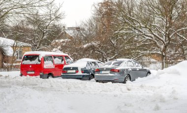 Lutsk, Ukrayna - 12 Şubat 2020: Tipiden sonra şehir caddesi. Kar ve buza sıkışmış bir araba. Gömülü araç kar yığınında. Kışın kar yağdıktan sonra park etmek. Temizlenmemiş yol. Rekor miktarda kar yağıyor.