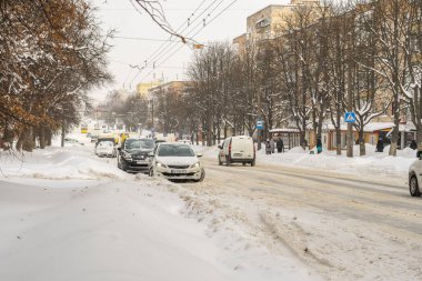Lutsk, Ukrayna - 12 Şubat 2020: Kar ve buzda sıkışmış araba. Kar fırtınasından sonra şehir caddesi. Gömülü araç kar yığınında. Kışın kar yağdıktan sonra park etmek. Temizlenmemiş yol. Rekor miktarda kar yağıyor.