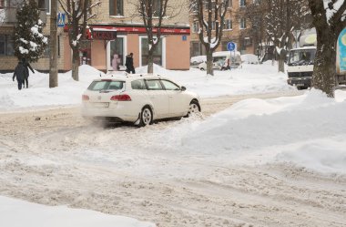 Lutsk, Ukrayna - 12 Şubat 2020: Kar ve buzda sıkışmış araba. Kar fırtınasından sonra şehir caddesi. Gömülü araç kar yığınında. Kışın kar yağdıktan sonra park etmek. Temizlenmemiş yol. Rekor miktarda kar yağıyor.