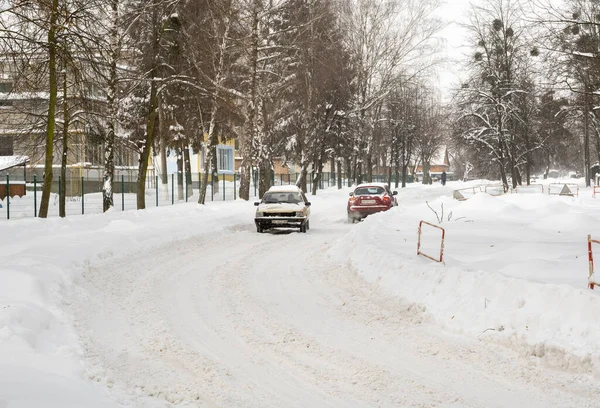 Lutsk, Ukrayna - 12 Şubat 2020: Kar fırtınasından sonra sokaktaki insanlar. Kar fırtınasından sonra şehir caddesi. Rekor miktarda kar yağıyor. Temizlenmemiş kaygan yollar ve kışın kaldırım. Kar yağışı içindeki arabalar
