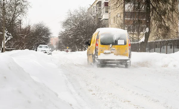 Lutsk, Ukrayna - 12 Şubat 2020: Kar ve buzda sıkışmış araba. Kar fırtınasından sonra şehir caddesi. Gömülü araç kar yığınında. Kışın kar yağdıktan sonra park etmek. Temizlenmemiş yol. Rekor miktarda kar yağıyor.