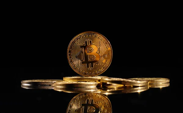 Bitcoin logolu yakın plan altın sikke. Şifreli para birimi Bitcoin BTC 'nin lideri siyah ayna yüzeyine karşı bozuk paraların tepesinde. Merkezi olmayan bir yığın dijital para birimi. Şifreli ödeme. Elektronik para.
