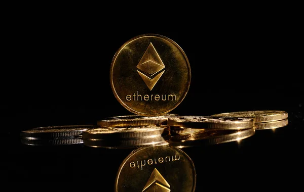 Yeni kripto para birimi Ethereum ETH 2.0 bitcoin paraların üstünde siyah arkaplana karşı. Eter logosuyla yakın plan altın para. Merkezi olmayan bir yığın dijital para birimi. Şifreli ödeme. Elektronik para
