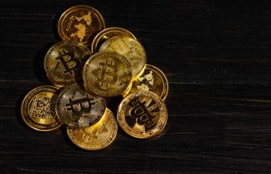 Siyah ahşap yüzeye karşı paraların tepesinde şifreli bitcoin BTC lideri. Bitcoin logolu yakın plan altın sikke. Merkezi olmayan dijital para birimleri yığını. Şifreli ödeme. Elektronik para
