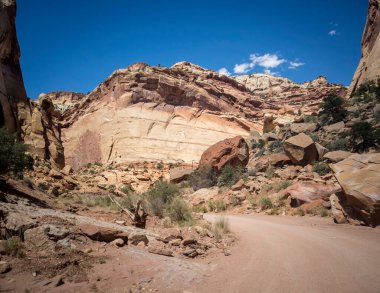 Unbelievable sandstone cliff and superlative domes with tumbleweeds on a hot summer partly cloudy day in Capitol Reef National Park in Southern Utah clipart