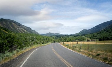 Utah 'taki Uinta Ulusal Ormanı' nda sıcak bir yaz gününde yol bulutlu.