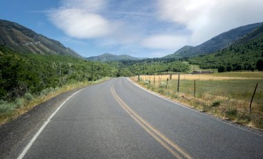 Cloudy sky with the road on a warm summer day in the Uinta National Forest in Utah clipart