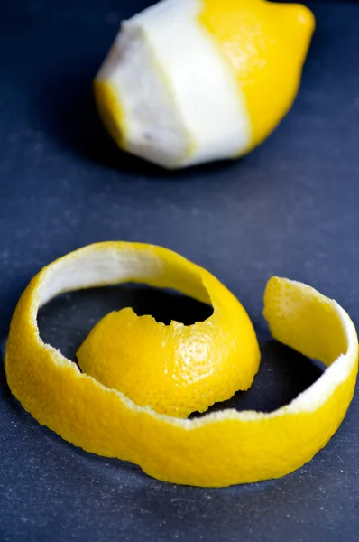 Лимон на черном фоне. Очищенный лимон — стоковое фото