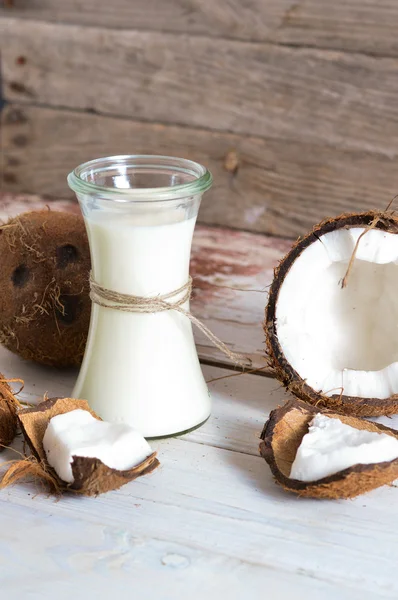 Noix de coco à l'huile de coco en pot sur fond bois Image En Vente