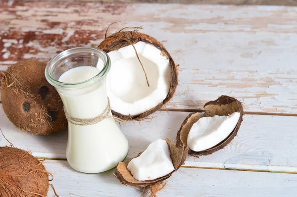 Noix de coco à l'huile de coco en pot sur fond bois Photos De Stock Libres De Droits