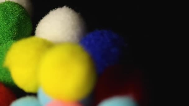 Fluffiga och färgglada små bollar på svart bakgrund — Stockvideo