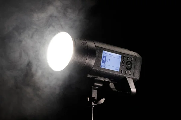 Studio luce flash sparare su sfondo nero con il fumo — Foto Stock