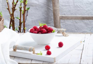 Kahvaltıda beyaz ahşap tepside seramik kasede taze ahududu..