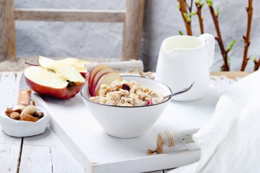 Kırsal beyaz ahşap tepside kırmızı elmalı yulaf ezmesi..