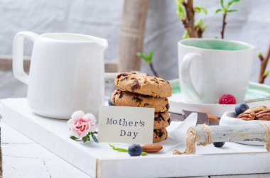 Anneler günü için beyaz tahta tepside kurabiyelerle kahvaltı.