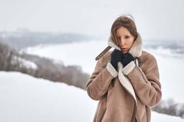 Kış şehrinin arka planında bir kız