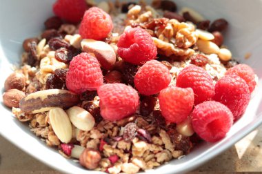 Gün ışığında ahududu ve fındıklı müsli.