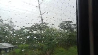 Yağmurlu bir mevsimde otobüs yolculuğu, yağmurlu bir günde yağmur damlası. Camdaki muson yağmurları. Su damlalı yağmurlu pencere.