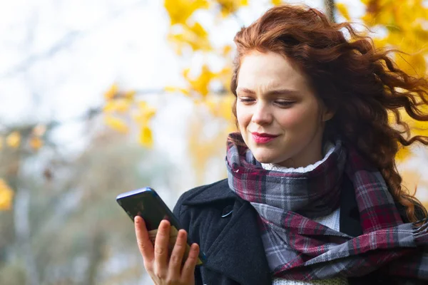 Mesaj yazan sürpriz bir kadın Avrupalı bir kadın cep telefonuna SMS mesajı gönderiyor. Şaşırmış genç bir kız cep telefonuna bakıyor, okuyor, sörf yapıyor, video görüşmesi yapıyor..