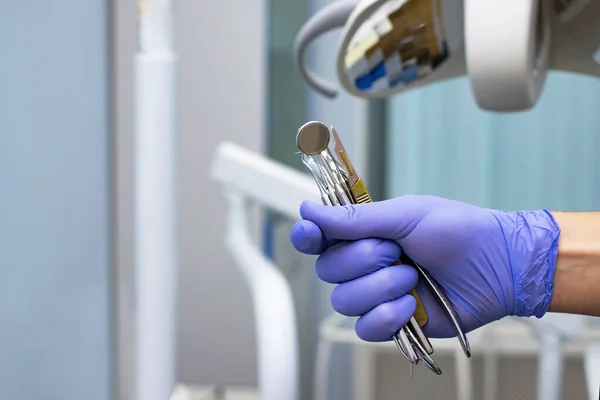 close-up of a dentist mirror, tools in the hands of a dentist on the background of a medical office.