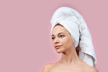 Kafasında havlu olan güzel bir kız, yana bakıyor. Pembe izole bir geçmişi olan güzel bir kadın. Boşluğu kopyala